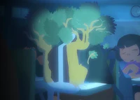 a girl is sitting at a table with a tree in the background